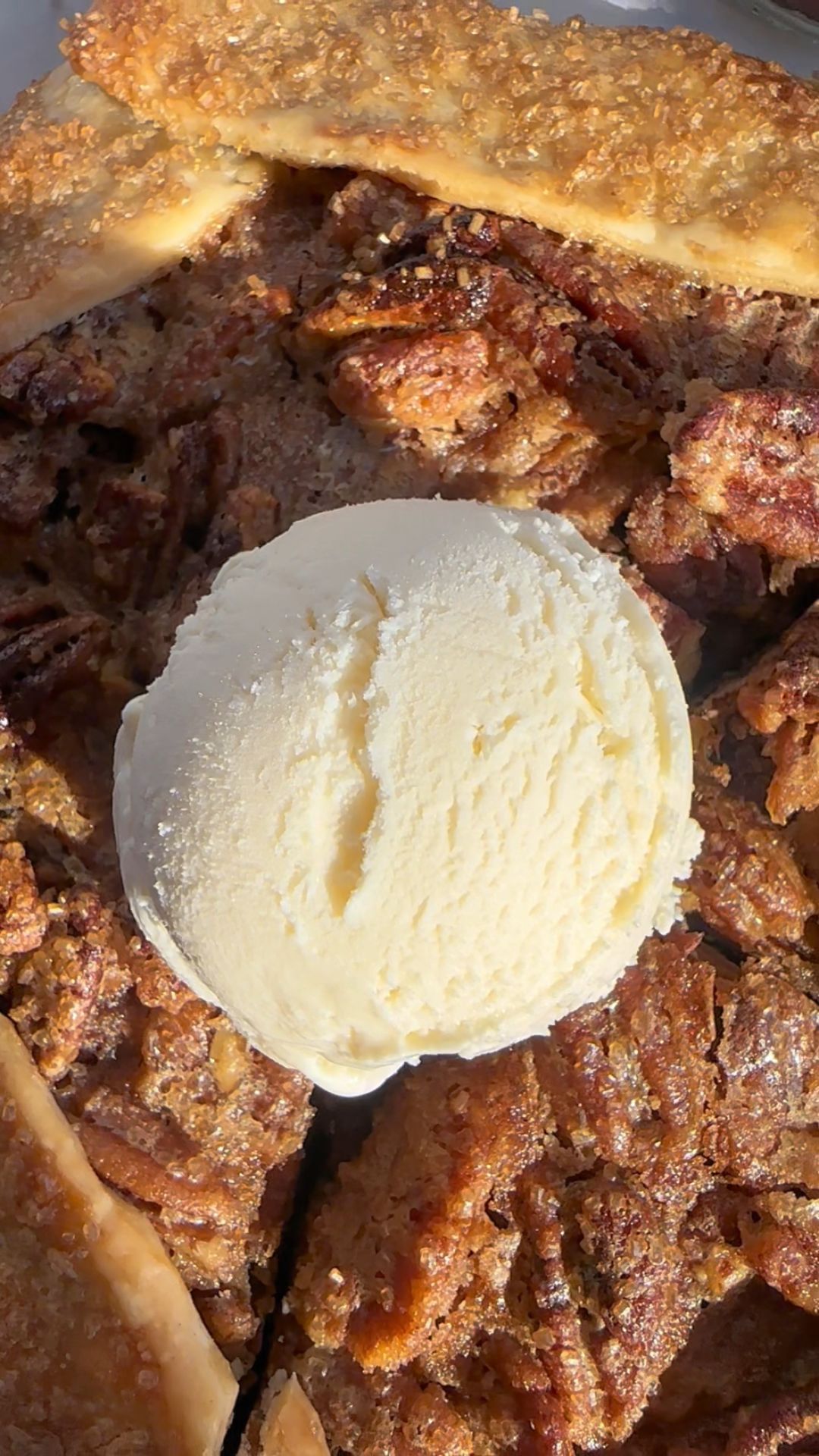 Pecan pie galette with pie crust and vanilla ice cream on top, in a close up image